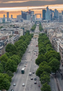 Champs Elysees günbatımında güzel manzara ve arka planda La Defence bölgesi, Paris