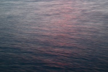 Bir Alberta gölünde şafak vakti gökyüzü sudan yansıyan dalgalarla hareket bulanıklaşır ve ortalama.