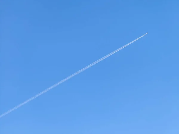 Bir jet uçağı ve açık mavi gökyüzünde bıraktığı izler.