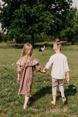Yeşil alanda yürüyen iki çocuk