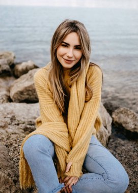 Açık havada şık giyinmiş güzel sarışın bir kadının portresi.