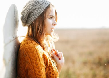 Doğada şık giysiler içinde güzel genç bir kadın.