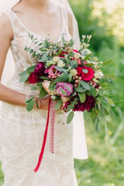 Gelinin elinde düğün buketinin yakın çekimi.