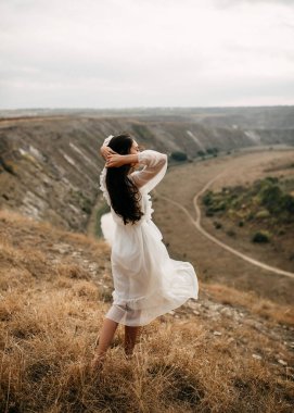 Doğada güzel, genç bir kadın. Arka planda güzel bir manzara.