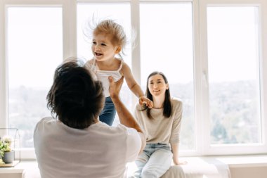 Güzel, genç bir aile evde birlikte vakit geçiriyor.