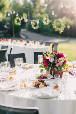Çiçekli ve gözlüklü düğün masası.