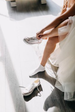 Beyaz elbiseli güzel gelinin, Chuck Taylor 'ı giydiği kesitli bir fotoğraf.