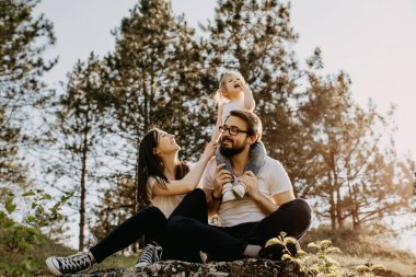 Mutlu genç aile doğada birlikte vakit geçiriyor.