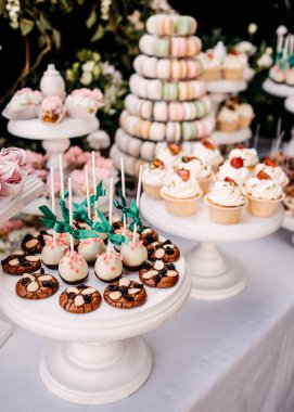 Düğün masası şekerlerle ve keklerle süslenmiş.