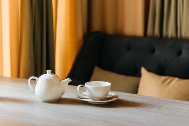 Bir fincan kahve ve koyu arkaplanı olan ahşap bir masa.