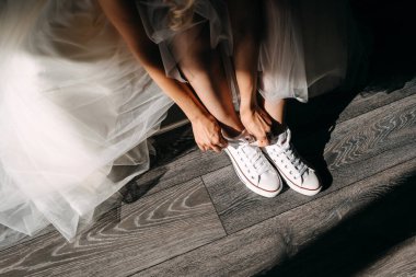 Beyaz elbiseli güzel gelinin, Chuck Taylor 'ı giydiği kesitli bir fotoğraf.