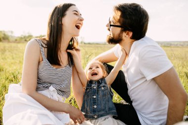 Mutlu genç aile doğada birlikte vakit geçiriyor.