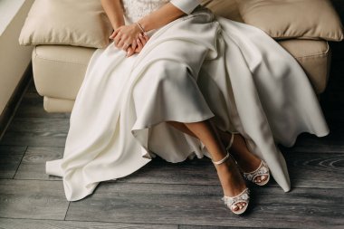 Beyaz elbiseli gelinin kanepeye oturduğu sahneyi.