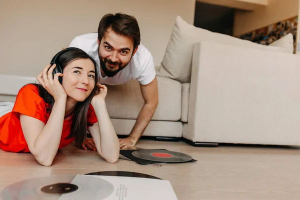 beautiful young couple listening vinyl records together at home