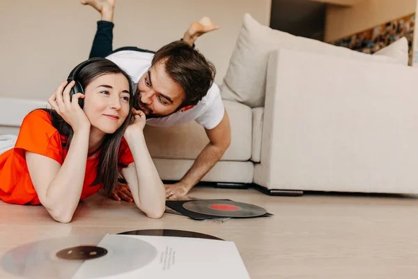 beautiful young couple listening vinyl records together at home