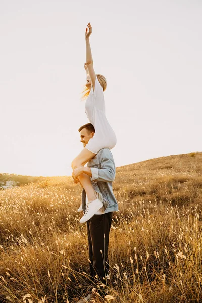 Mooie Jonge Vrouw Rijden Haar Vriendje Schouders Weide Tijdens Zonsondergang — Stockfoto