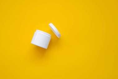 sarı arkaplanda beyaz kozmetik konteynır