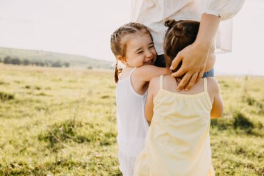 Anne ve sevimli küçük kızlar doğada birlikte vakit geçiriyorlar.
