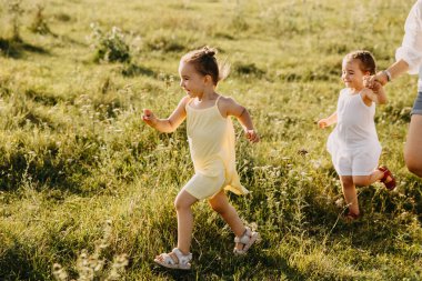 Anne ve sevimli küçük kızlar doğada birlikte vakit geçiriyorlar.