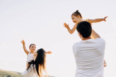 İki kızı olan genç ve güzel bir aile doğada birlikte vakit geçiriyorlar.