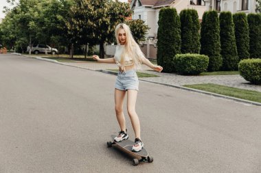 Sokakta uzun bir sörf tahtası olan güzel bir kadın.