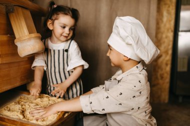Ağabey ve abla hamur işi için mısır hazırlıyor.