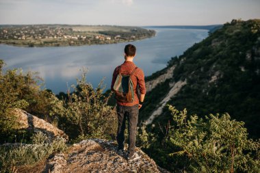 Doğada deri çantalı yakışıklı genç bir adamın portresi.