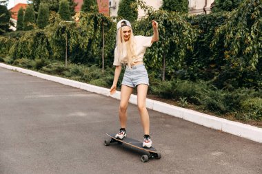 Sokakta uzun bir sörf tahtası olan güzel bir kadın.