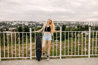 Sokakta uzun bir sörf tahtası olan güzel bir kadın.