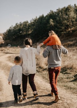 Doğada birlikte yürüyen genç bir ailenin arka planı.