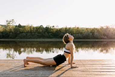 Eğitimden önce güneşli bir akşamda doğayı ısıtan güzel bir genç kadın.