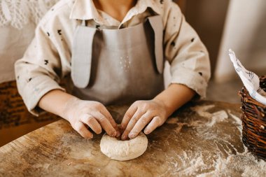Hamur işini hazırlayan sevimli küçük çocuğun yakın plan çekimi.