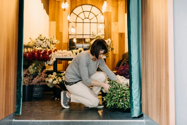 年轻的花匠做漂亮的丁香花束 — 图库照片