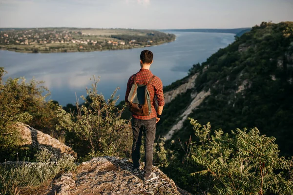 Doğada deri çantalı yakışıklı genç bir adamın portresi.