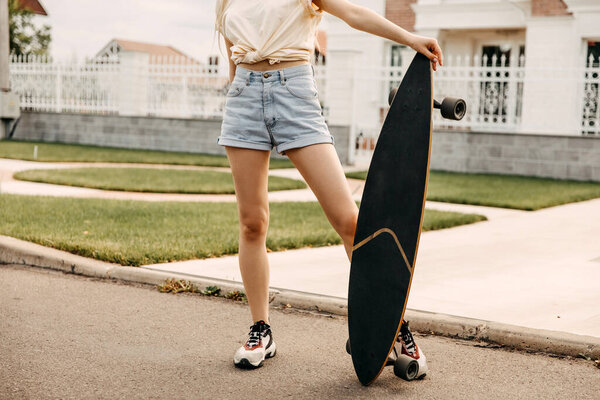 cropped shot of woman with long board on street
