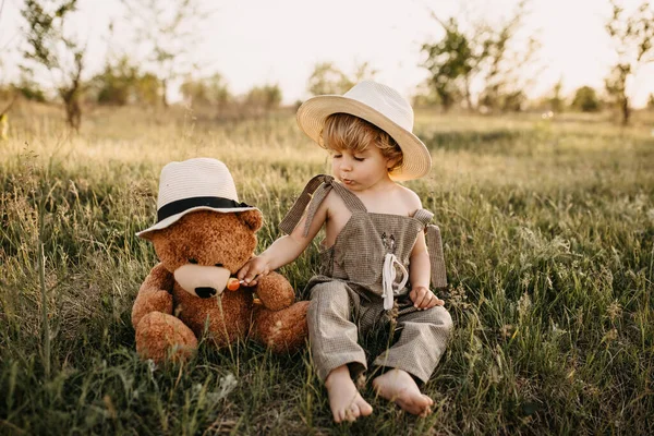 Portrait Adorable Little Boy Overall Teddy Bear Green Field Sunset — Stock Photo, Image