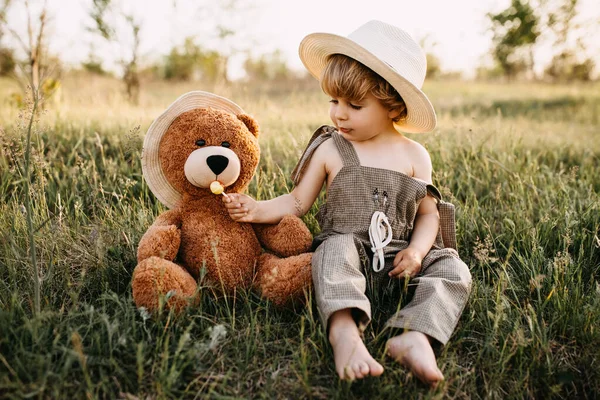 Portrait Adorable Little Boy Overall Teddy Bear Green Field Sunset — Stock Photo, Image