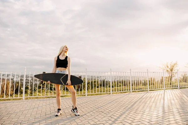 Sokakta uzun bir sörf tahtası olan güzel bir kadın.