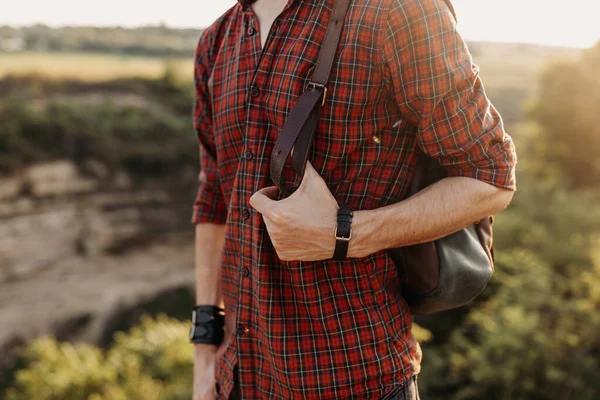 cropped shot of man with leather backpack on nature