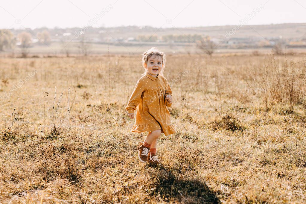 adorable little girl in stylish dress on nature