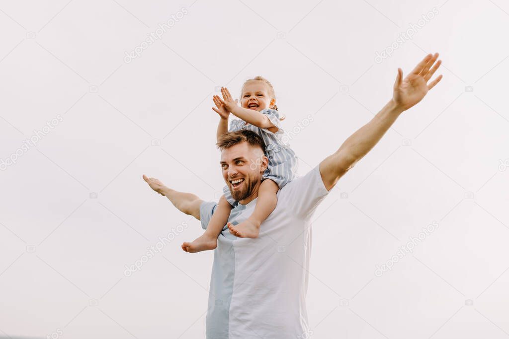 portrait of father and daughter playing together on nature