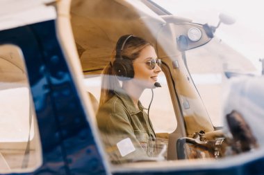 Uçağın içinde oturan güzel sarışın pilotun portresi.