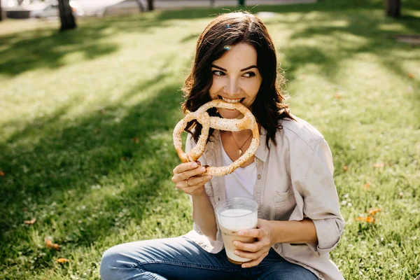 Portrait Beautiful Young Woman Plastic Cup Latte Pretzel Relaxing Grass — Stock Photo, Image