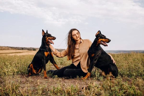 Portret Pięknej Kobiety Dwoma Dobermanami Siedzącymi Przyrodzie — Zdjęcie stockowe