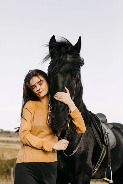 自然の中で黒い馬を持つ美しい女性の肖像画 — ストック写真