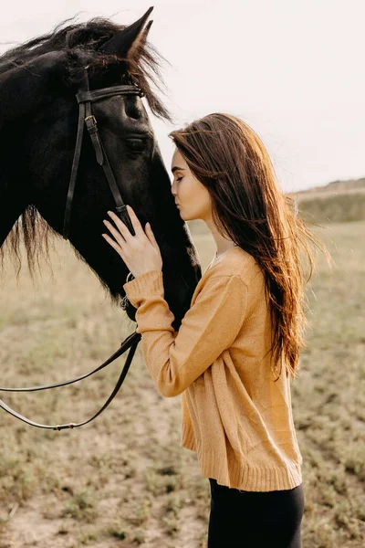 自然の中で黒い馬を持つ美しい女性の肖像画 — ストック写真