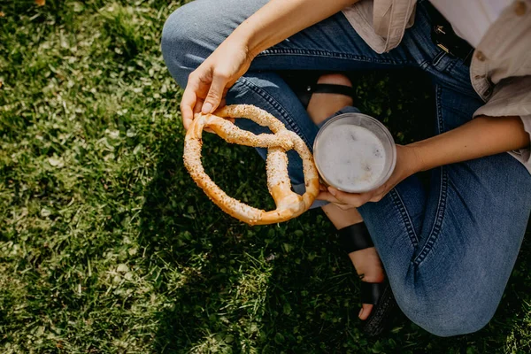 Tiro Cortado Mulher Com Copo Plástico Latte Pretzel Relaxante Grama — Fotografia de Stock