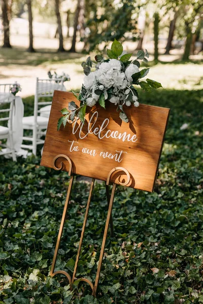 close-up shot of wedding sign board decorated with flowers