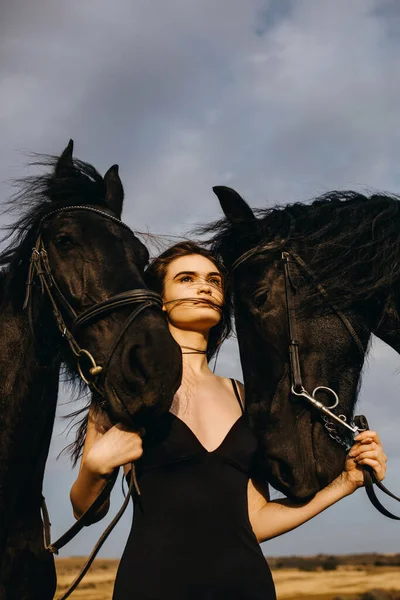 Portret Pięknej Kobiety Czarnej Sukience Dwoma Końmi Przyrodzie — Zdjęcie stockowe