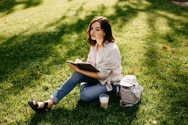 Portret Van Mooie Jonge Vrouw Schrijven Notebook Terwijl Zitten Gras — Stockfoto